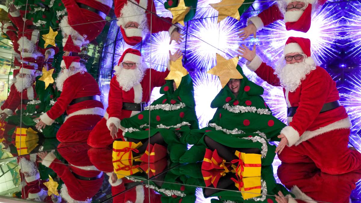 Santa and a girl dressed as a Christmas Tree pose in a colourful box at Camera Obscura