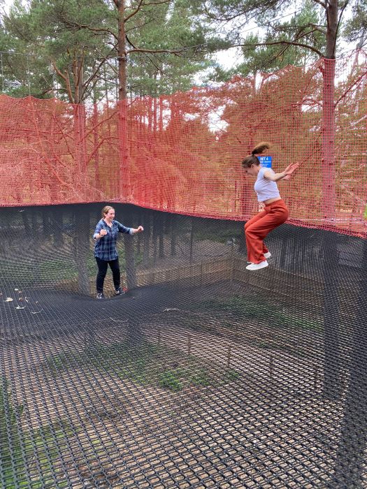 Two girls jump on a net suspended high above the ground at Landmark Forest Adventure Park