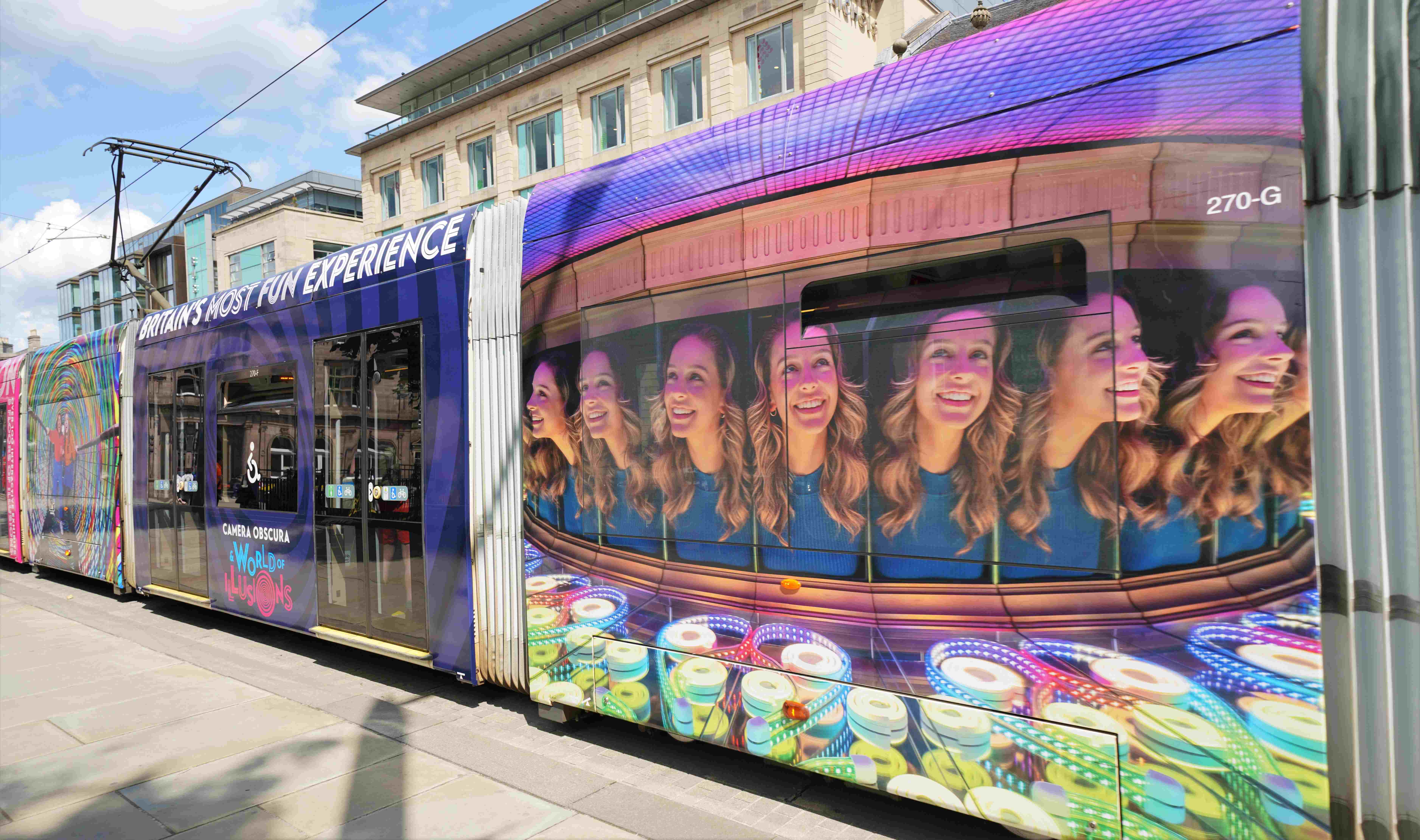 Edinburgh Tram with large pictures of exhibits from Camera Obscura on the side