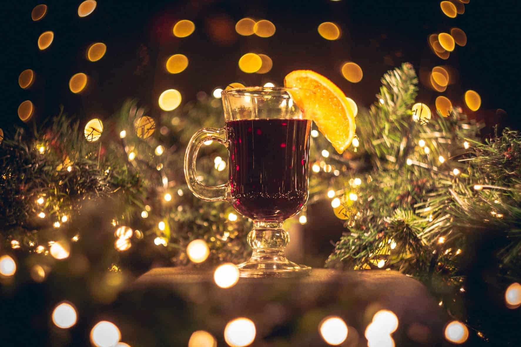 A picture of a glass of red wine with Christmas lights in the background from The Cauldron, Edinburgh