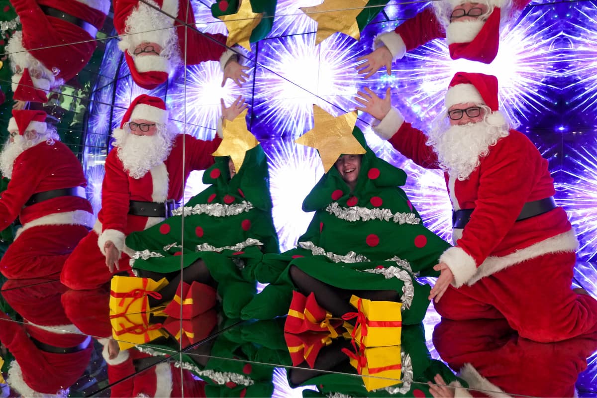 A person dressed as a Christmas Tree and Santa sit inside a mirrored box at Camera Obscura