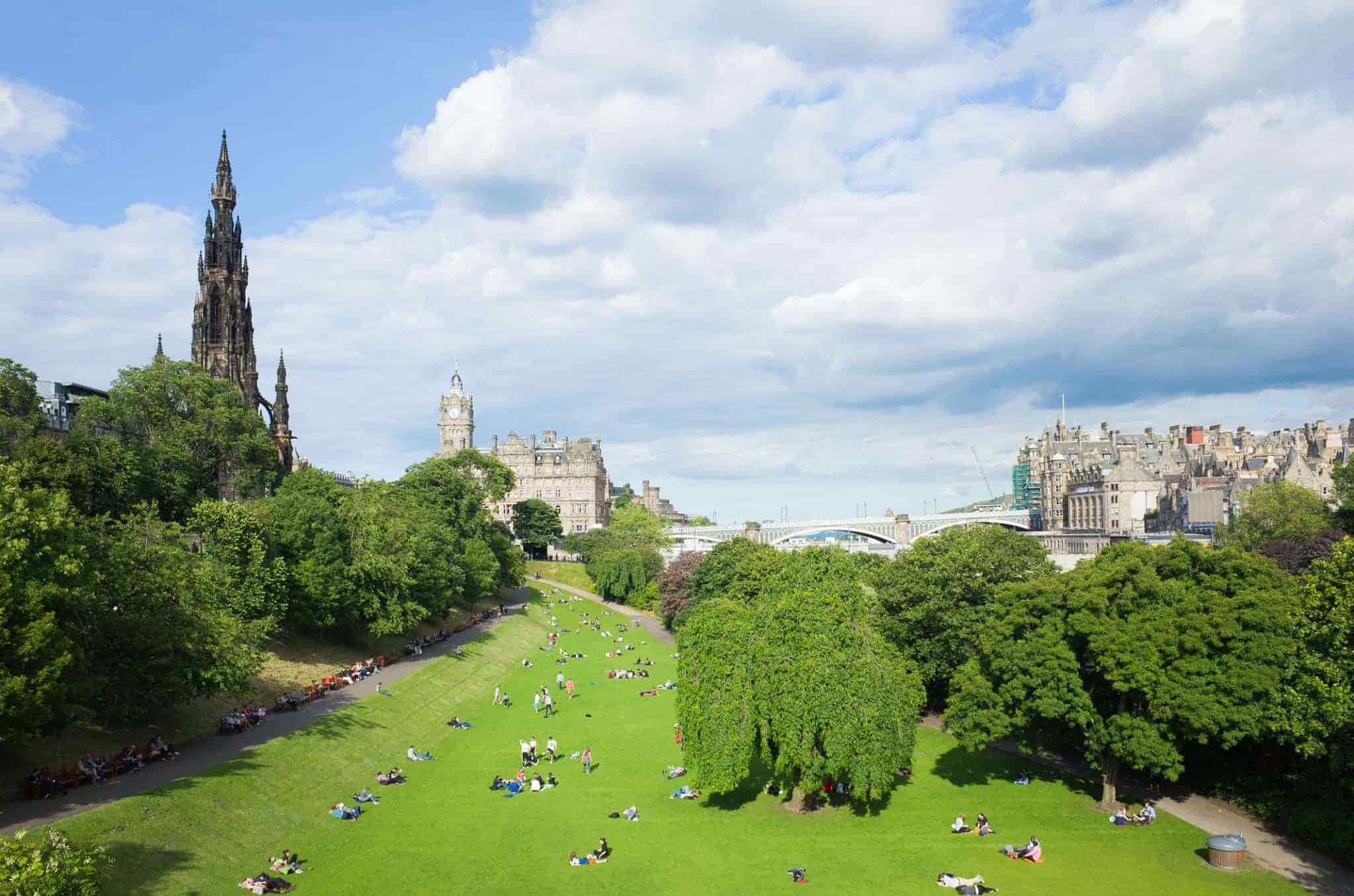 Princes Street Gardens in Edinburgh, people lie on the grass in the sunshine