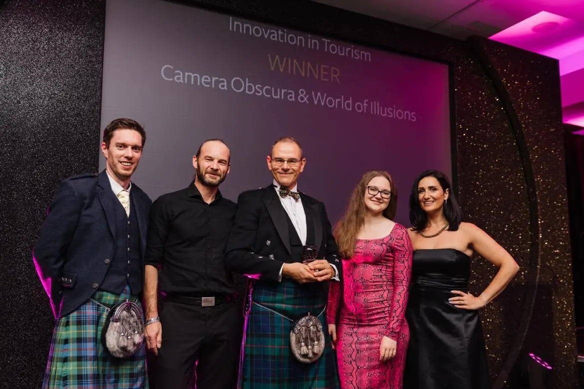 The team from Camera Obscura accept the regional thistle award on stage with guest presenters 